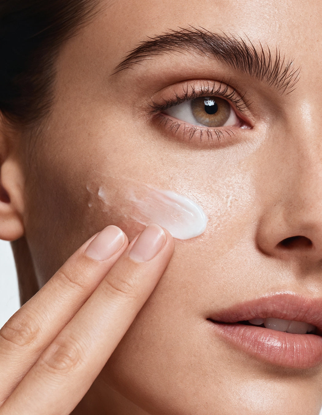 Model applying MD® Ultimate White brightening cream to the cheek — physician-formulated by Dr. Susan Lin, M.D., hydroquinone-free, for the look of dark spots and uneven tone