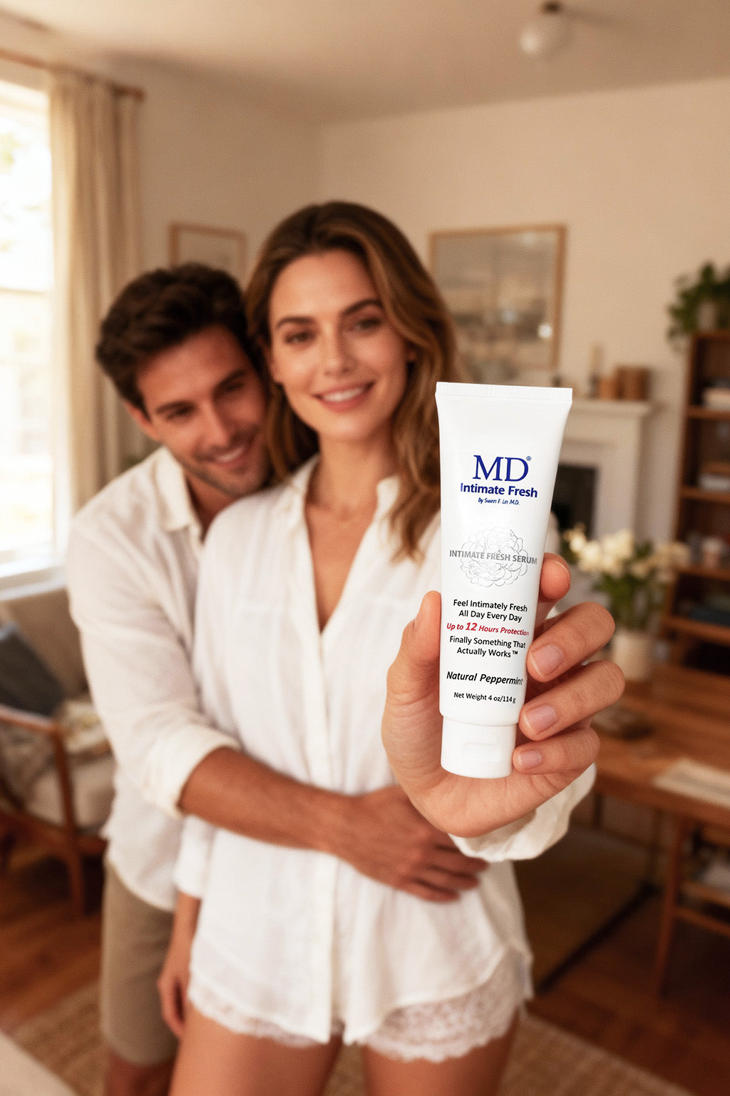 A smiling couple at home holding MD® Intimate Fresh, the physician-formulated leave-on hygiene serum with natural peppermint.